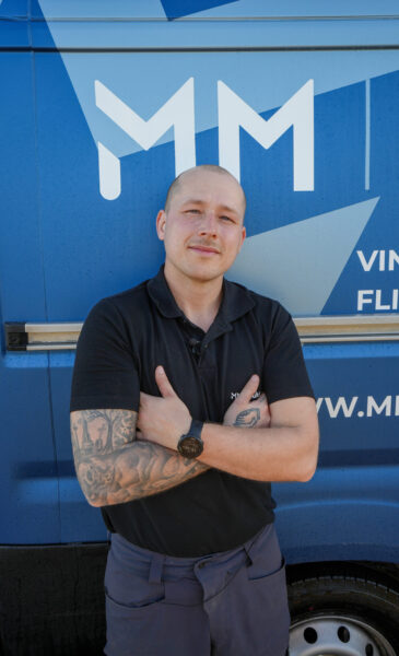 Medarbejder fra MM Multipartner foran firmabilen